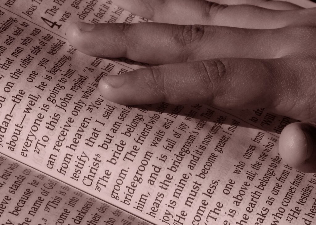 kids hand on Bible
